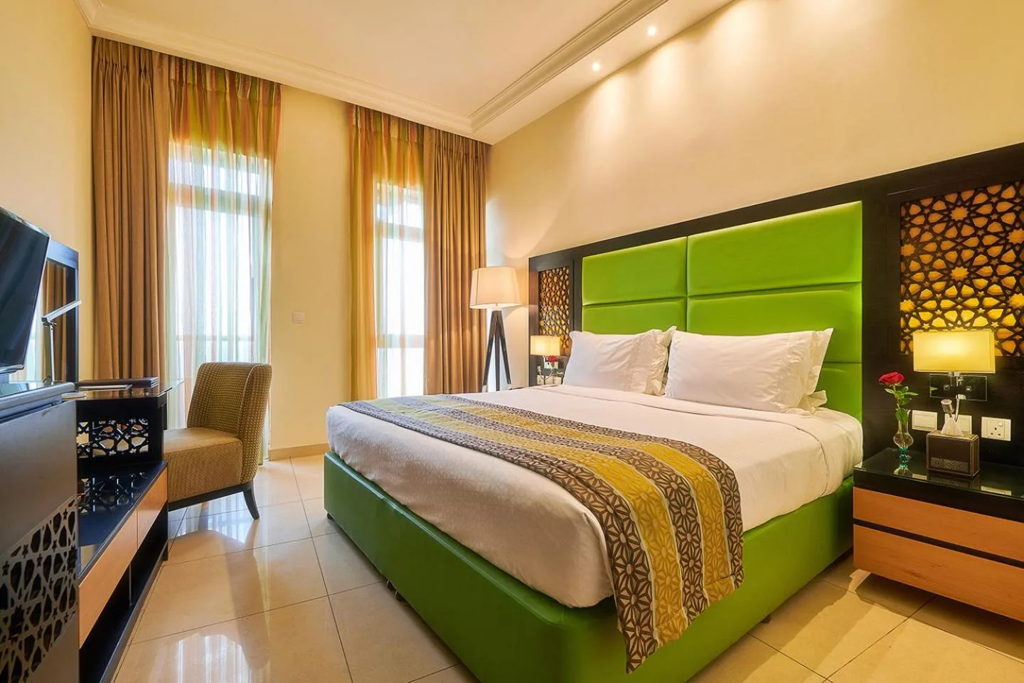 Chambre standard au Bahi Ajman Palace Hotel à Ajman avec lit king-size, télévision et grandes fenêtres