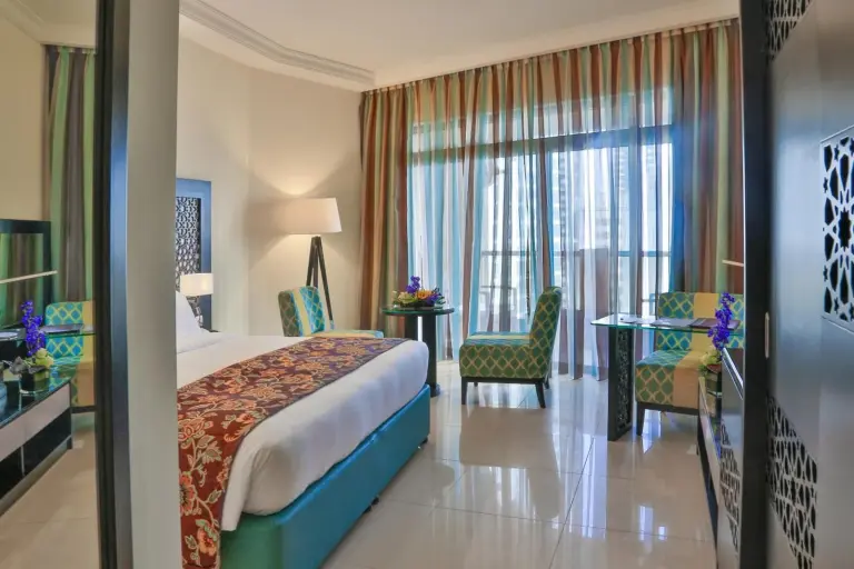 Chambre twin au Bahi Ajman Palace Hotel à Ajman avec coin salon sur le balcon et vue sur la ville