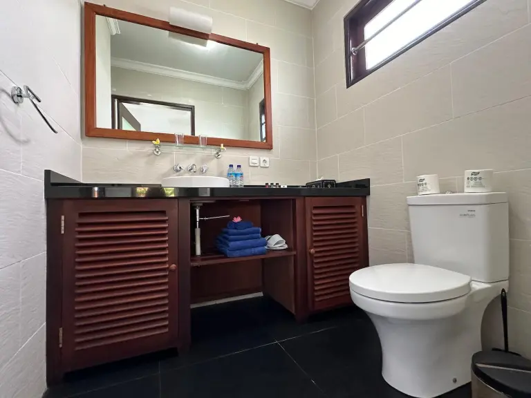 Bale Solah Lombok Holiday Resort – hôtel à Mataram, Indonésie – un lit avec draps et oreillers blancs dans une chambre au Bale Solah Lombok Holiday Resort à Senggigi