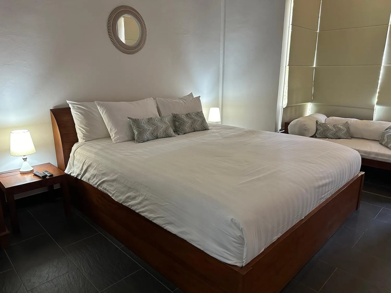 Bale Solah Lombok Holiday Resort – hôtel à Mataram, Indonésie – une chambre avec un grand lit avec draps et oreillers blancs au Bale Solah Lombok Holiday Resort à Senggigi