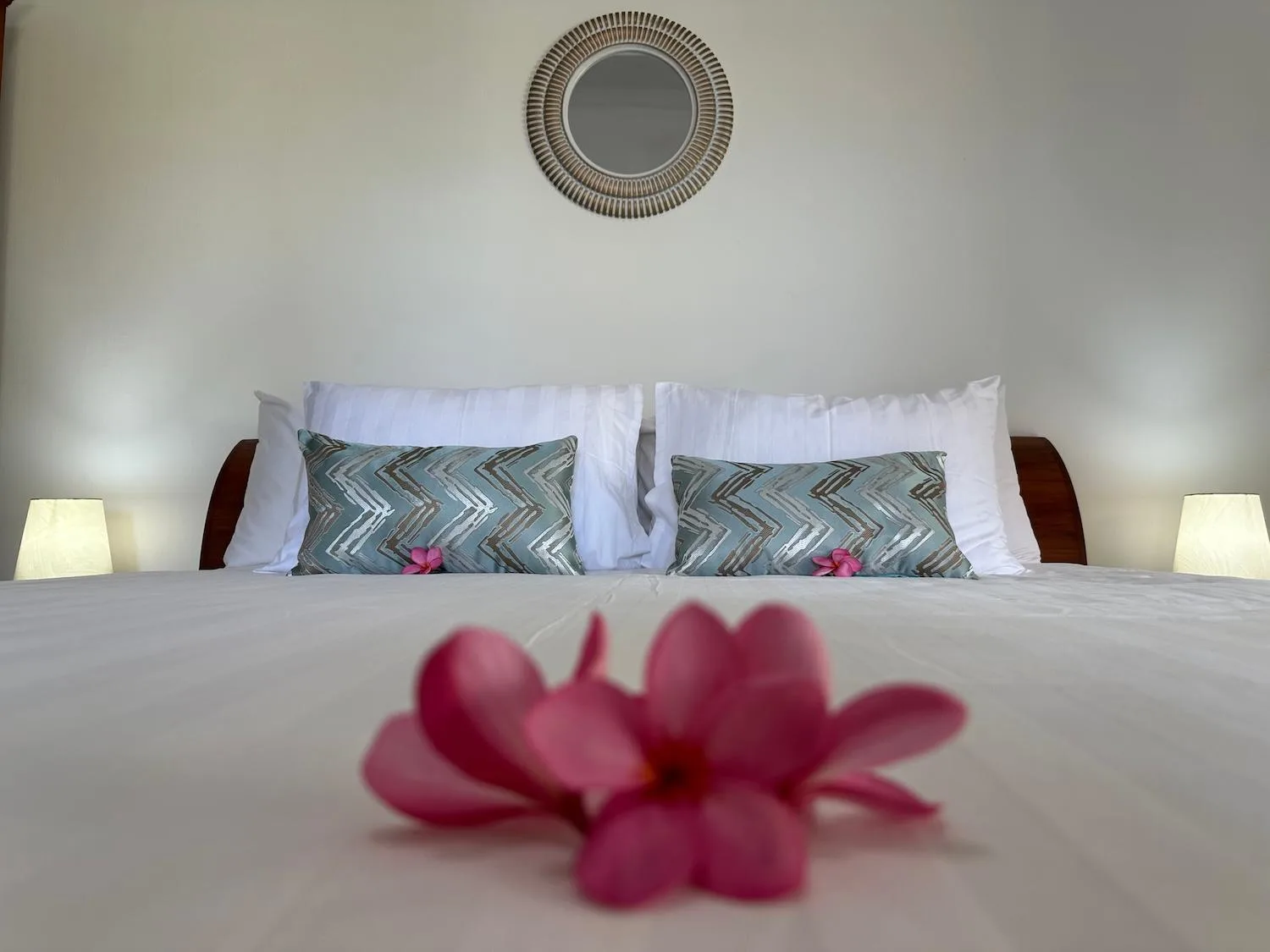 Chambre king au Bale Solah Lombok Holiday Resort à Mataram avec décoration florale et lampes de chevet