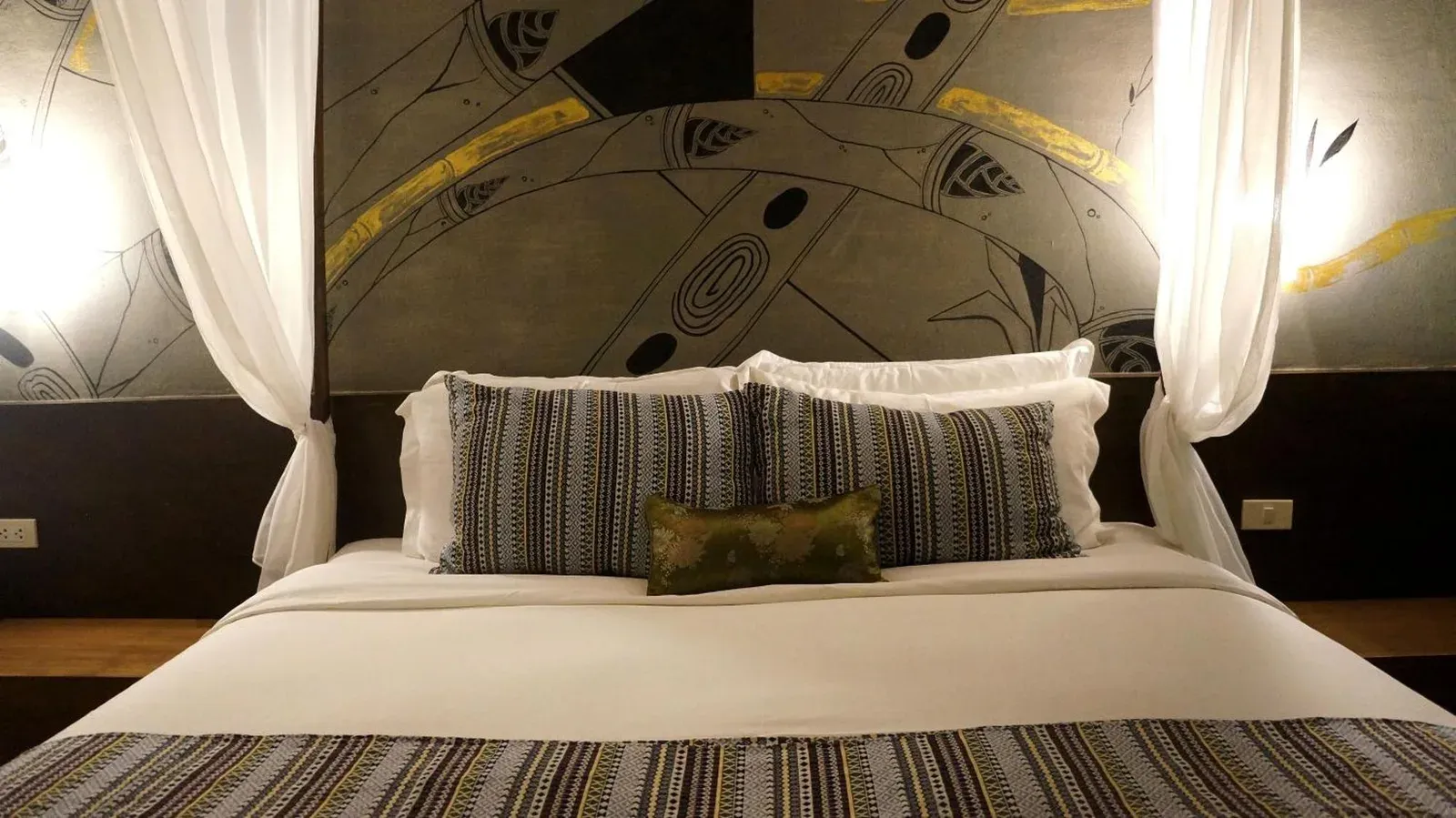 Bamboori Boutique Resort Chiang Mai king bed with striped pillows and decorative mural wall
