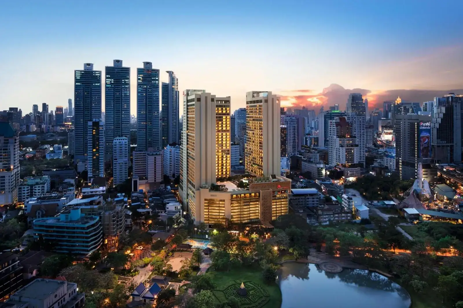 Vista aérea de Bangkok Marriott Marquis Queens Park que muestra su arquitectura moderna contra el perfil urbano de Bangkok.