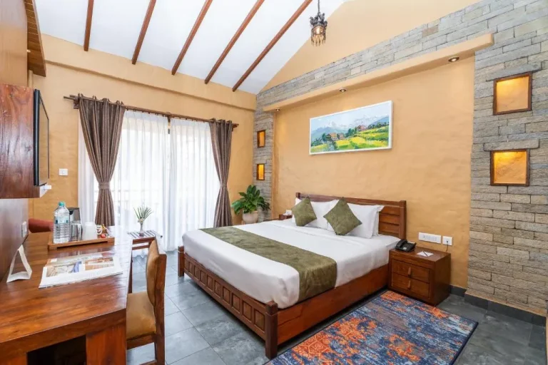 Cozy deluxe room at Bar Peepal Resort, featuring a comfortable bed and modern decor.