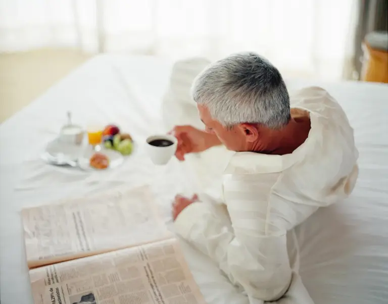 Gast beim Frühstück im Bett im Barcelo Al Jaddaf, Dubai mit Kaffee, Obst und Zeitung