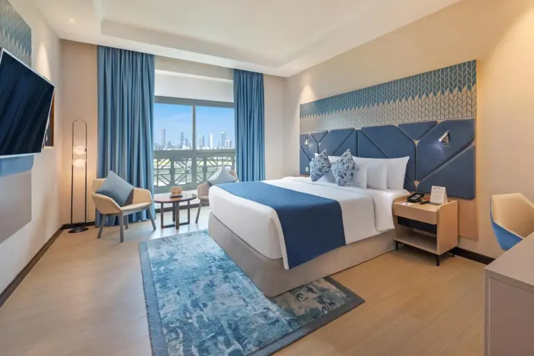 King-Gästezimmer im Barcelo Al Jaddaf, Dubai mit Balkonblick und modernem blauem Dekor