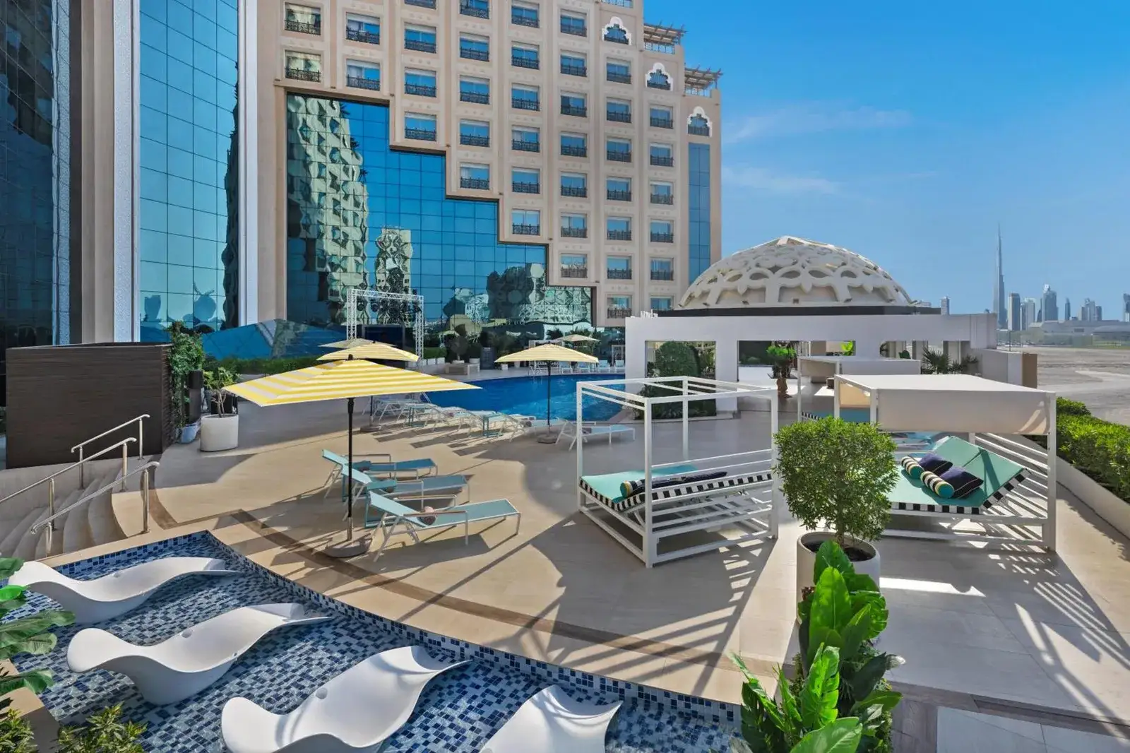 Pooldeck im Barcelo Al Jaddaf, Dubai mit Liegen, Cabanas und Stadtblick