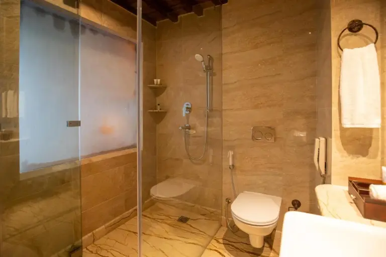 Baño moderno en Basera Boutique Hotel - La escapada oculta de Kathmandu, con ducha de cristal, inodoro y acabados de mármol.