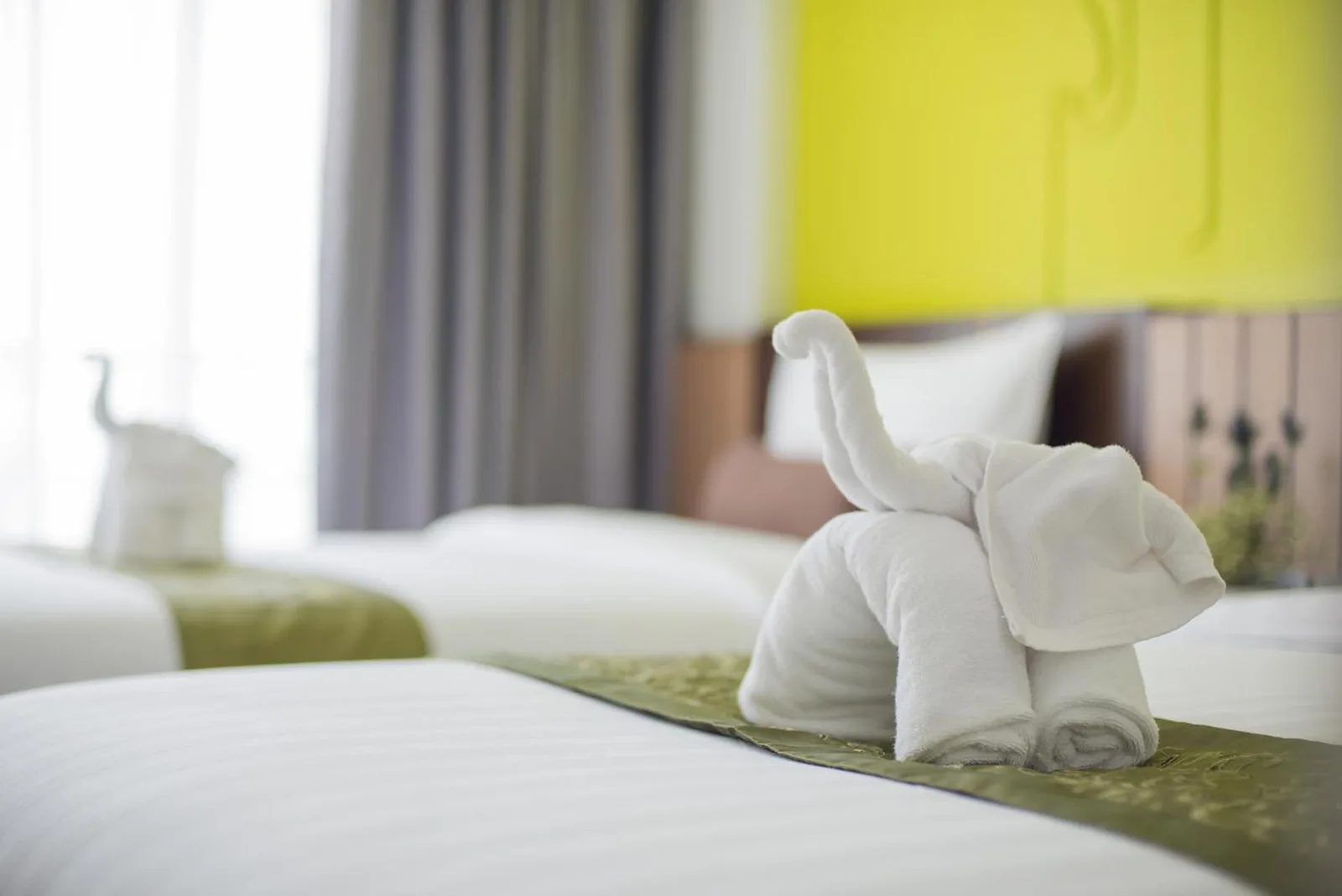Decoración de toalla con forma de elefante sobre una cama en Bay Beach Resort Jomtien en Pattaya