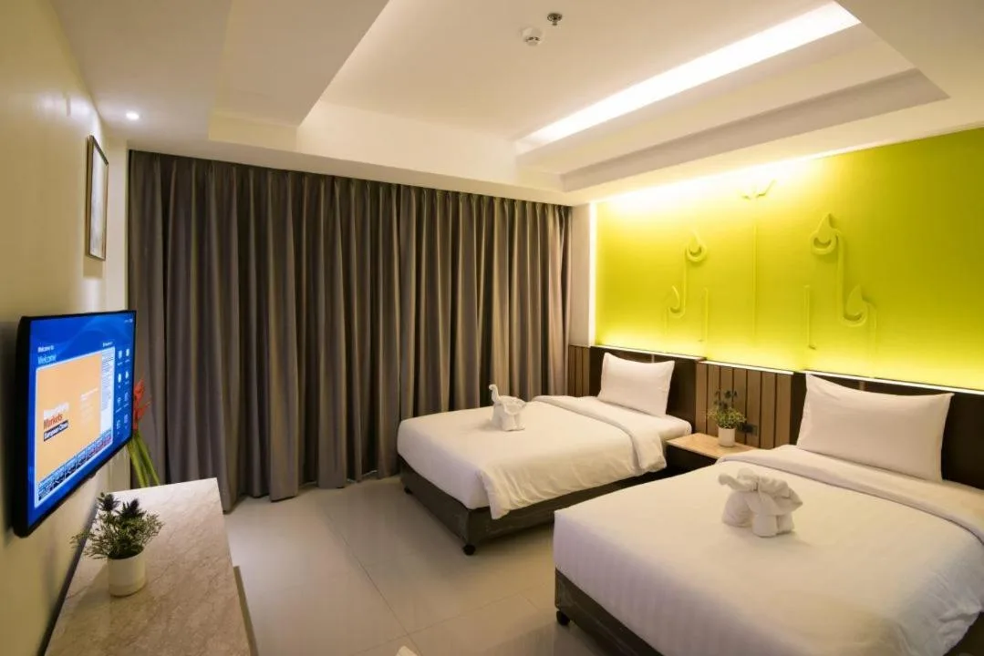 Dormitorio Twin en Bay Beach Resort Jomtien en Pattaya con pared de acento verde lima y dos camas individuales