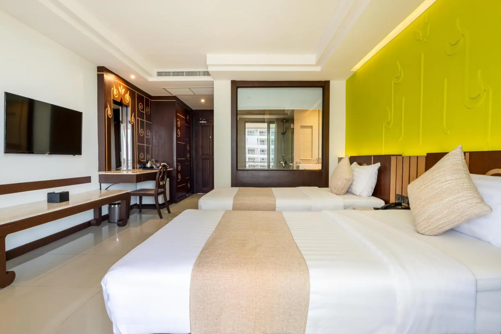 Interior de habitación Twin en Bay Beach Resort Jomtien en Pattaya con escritorio, TV y armario