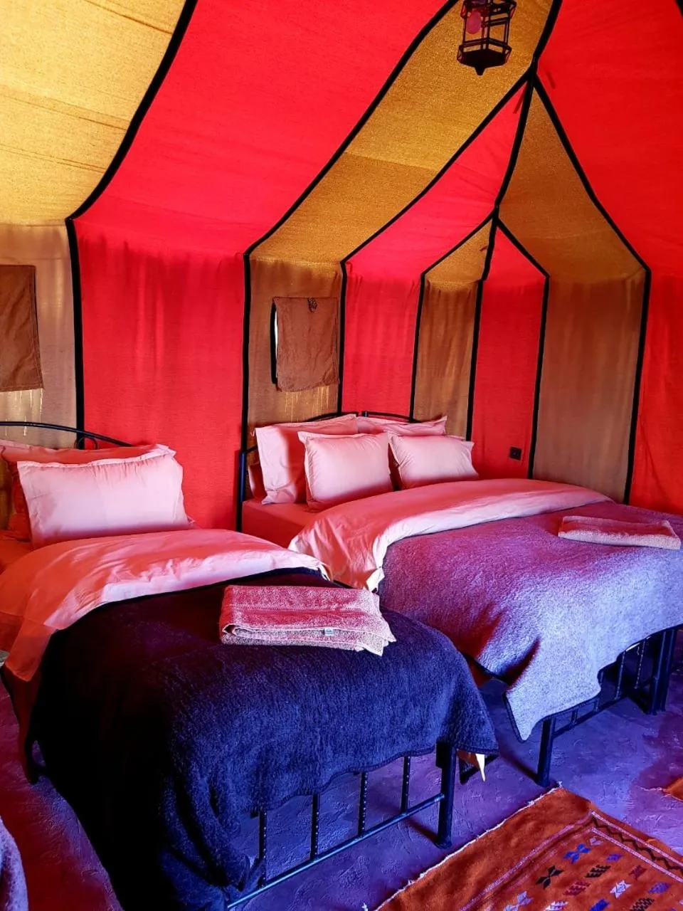 Bedouin Desert Camp – Merzouga, Morocco hotel – a large tent with tables and chairs in it at Bedouin Desert Camp in Merzouga