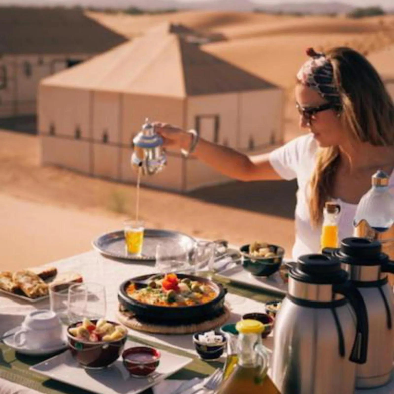 Wüstendinner-Erlebnis im Berber Soul luxury Camp in Merzouga mit einem im Freien neben den Camp-Zelten gedeckten Tisch