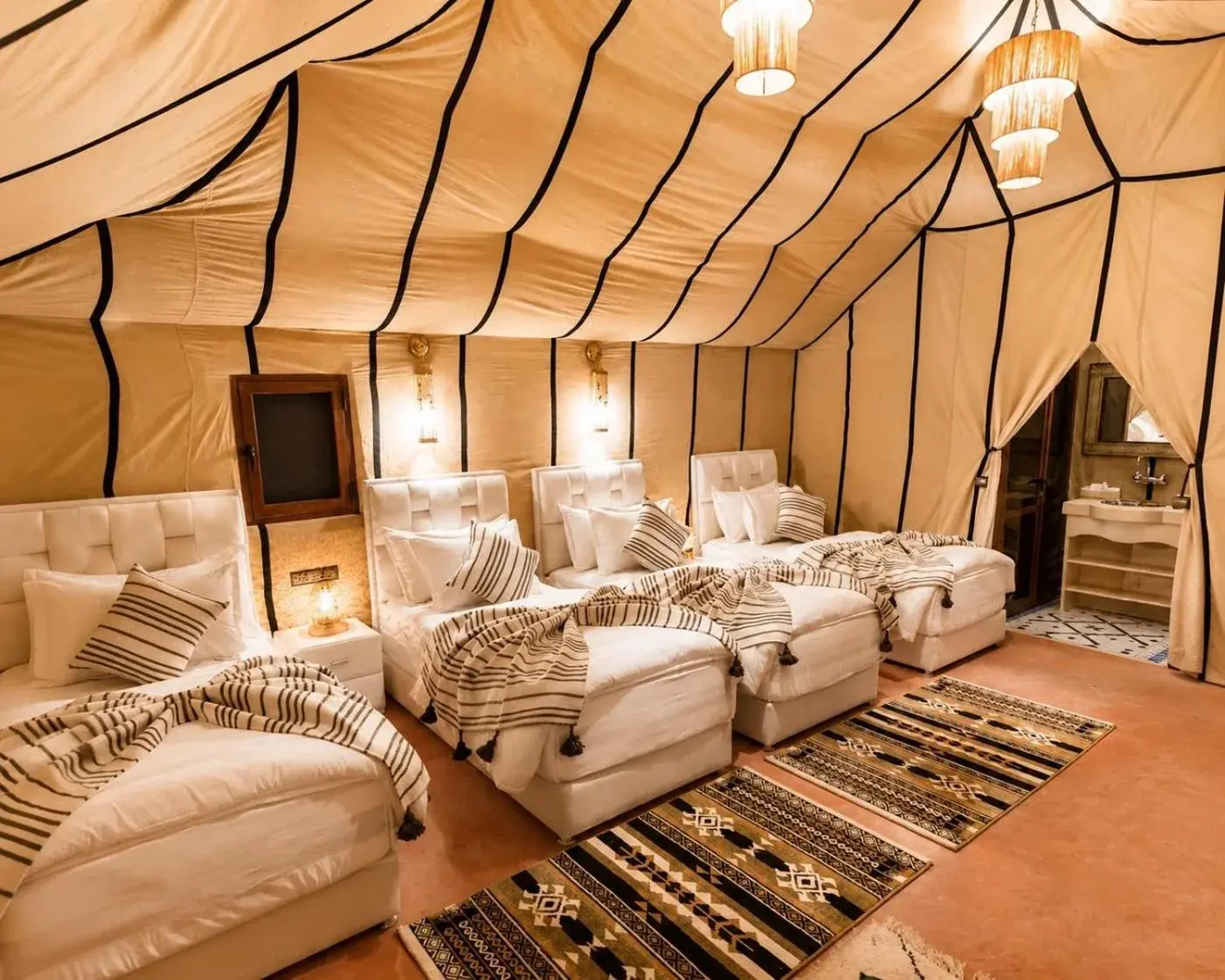 Berber Spirit Luxury Camp – hôtel à Merzouga, Maroc – une chambre avec deux lits et un tapis au Berber Spirit Luxury Camp à Merzouga