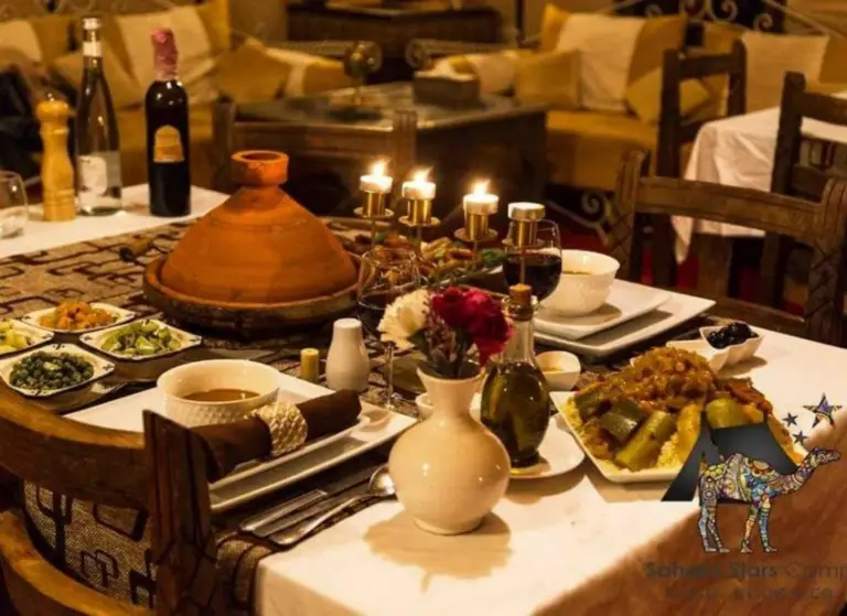 Best Classic Sahara Experiences in Merzouga dining table with traditional Moroccan dishes and candles