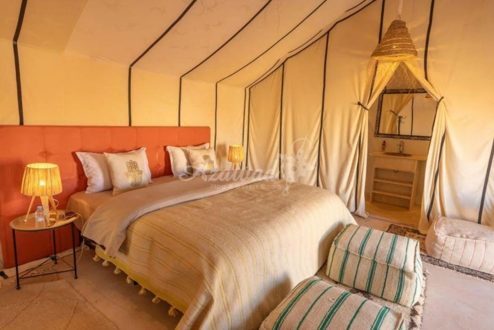 Best Classic Sahara Experiences in Merzouga luxury tent bedroom with a king bed and bedside lamps