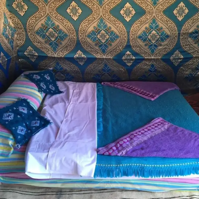 Cama doble con decoración estampada dentro de Bivouac la fibule des Dunes en Merzouga