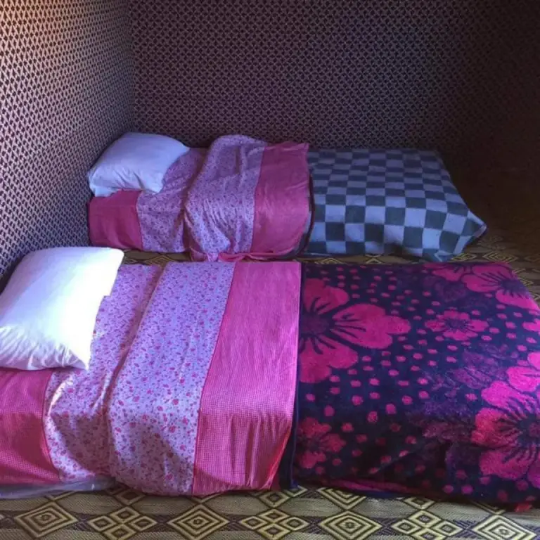 Camas individuales dentro de una tienda en Bivouac la fibule des Dunes en Merzouga