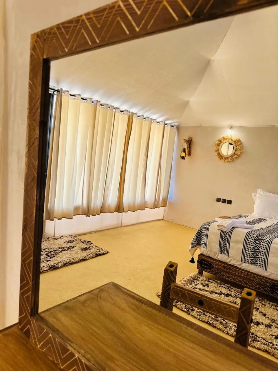 Spacious guest tent bedroom at Brilliant luxury camp in Merzouga with curtains and bed