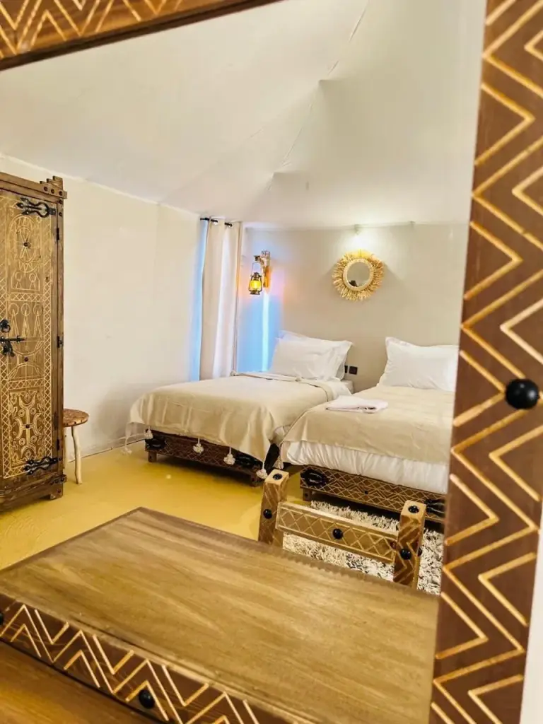 Twin bedroom view at Brilliant luxury camp in Merzouga seen through a decorative mirror frame