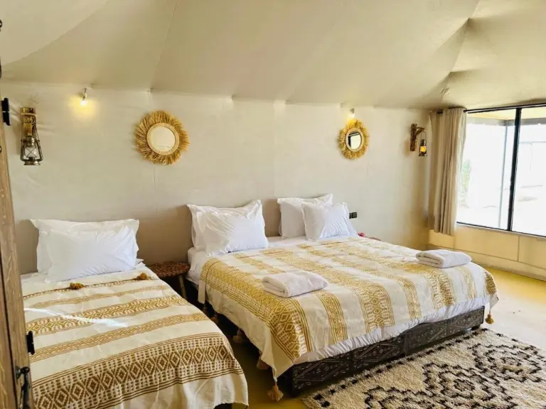 Twin and double bed guest tent room at Brilliant luxury camp in Merzouga with patterned rugs