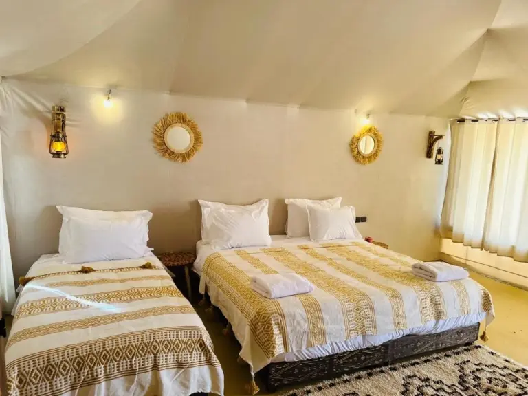Twin bed guest tent interior at Brilliant luxury camp in Merzouga with Moroccan decor