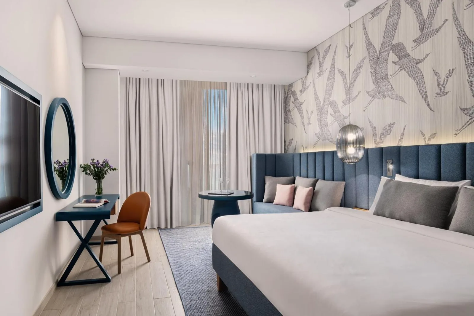 Habitación king en C Central Hotel and Resort The Palm en Dubai con escritorio, cortinas del balcón y decoración contemporánea
