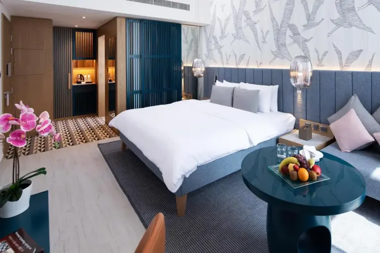 Dormitorio de suite en C Central Hotel and Resort The Palm en Dubai con zona de estar y bandeja de fruta