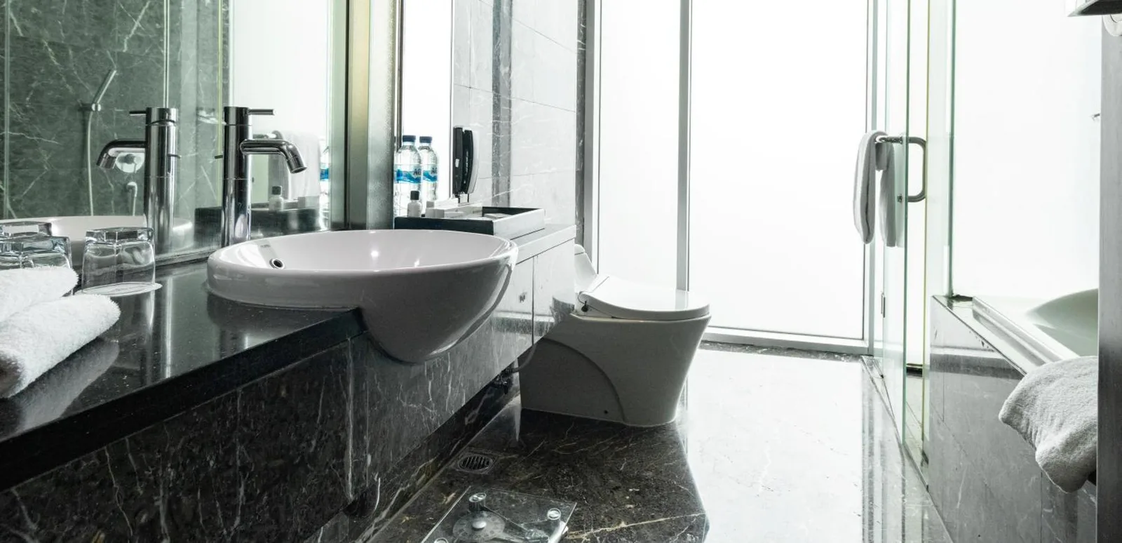 Baño moderno de Cambridge Hotel Medan con lavabo, inodoro y ducha de cristal