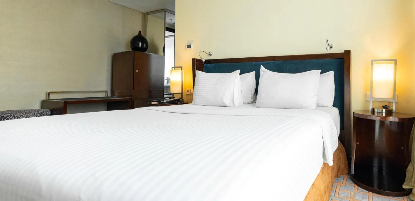 Habitación estándar de Cambridge Hotel Medan con cama doble y lámparas de noche