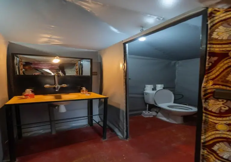 Camel Trekking Desert Camp in Merzouga private bathroom with sink and toilet inside a tent