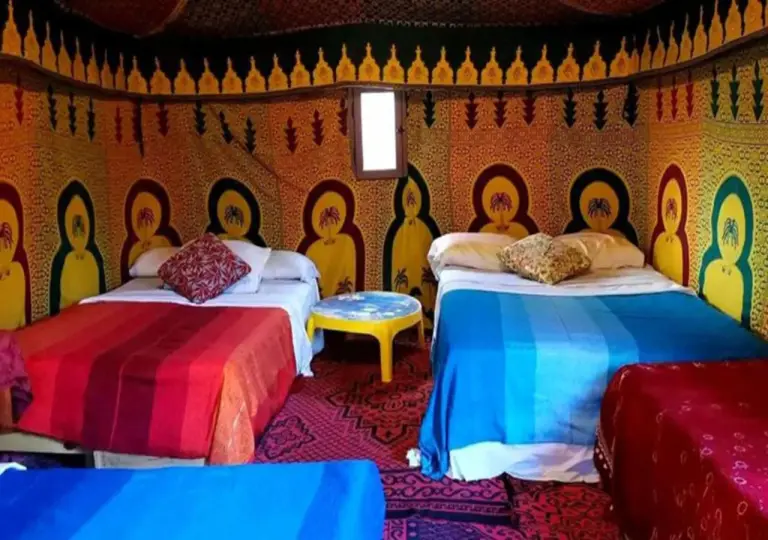 Camel Trekking Desert Camp in Merzouga family tent room with multiple beds and colorful decor