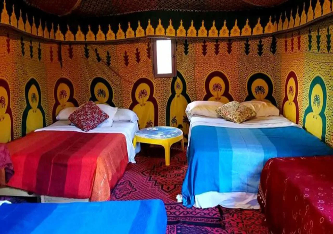Camel Trekking Desert Camp in Merzouga family tent room with multiple beds and colorful decor