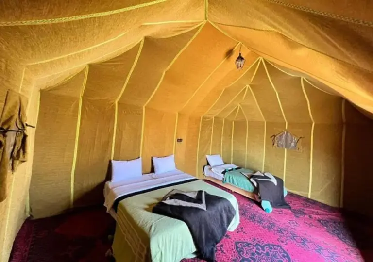 Camel Trekking Desert Camp in Merzouga twin-bed tent room with yellow canvas walls