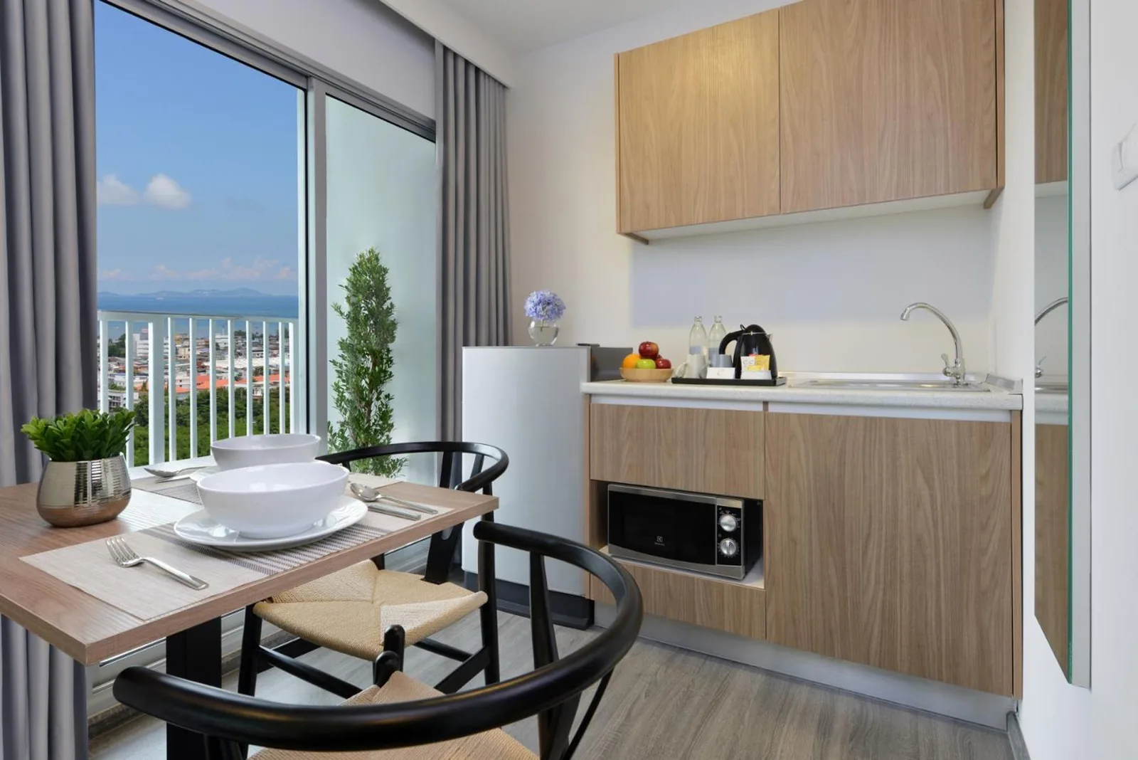 Kitchenette and dining area at Centre Point Prime Hotel Pattaya with balcony views