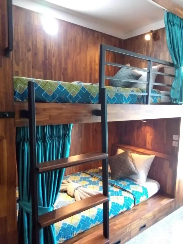 Single bed detail at Cha Li's Family Hotel&Hostel in Pai with patterned blanket and folded towel