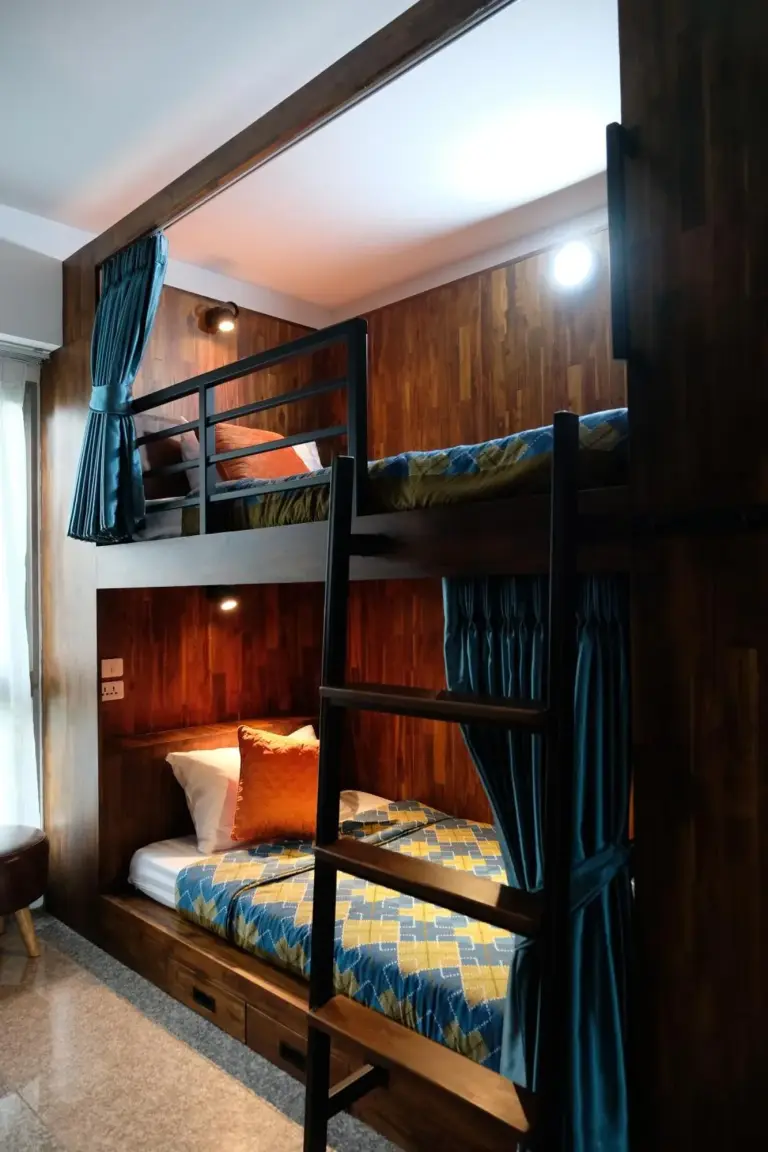 Shared dormitory room at Cha Li's Family Hotel&Hostel in Pai with bunk beds and a seated guest