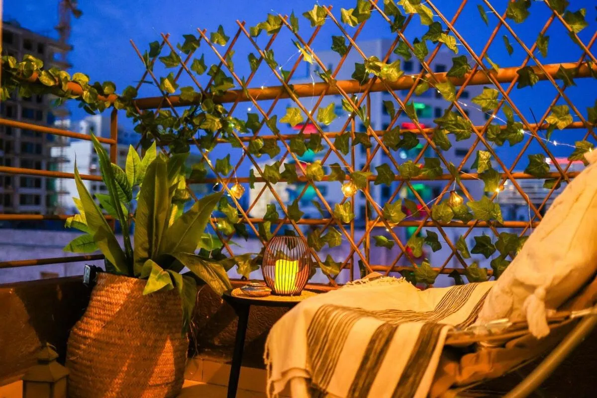 Appartement charmant avec balcon cosy à Tanger, mettant en valeur un fauteuil relaxant et des plantes