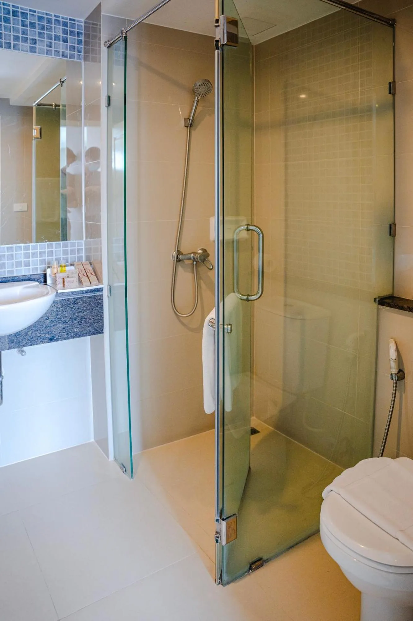 Salle de bains moderne avec douche vitrée et toilettes à Cinnamon Hotel Bangkok à Bangkok