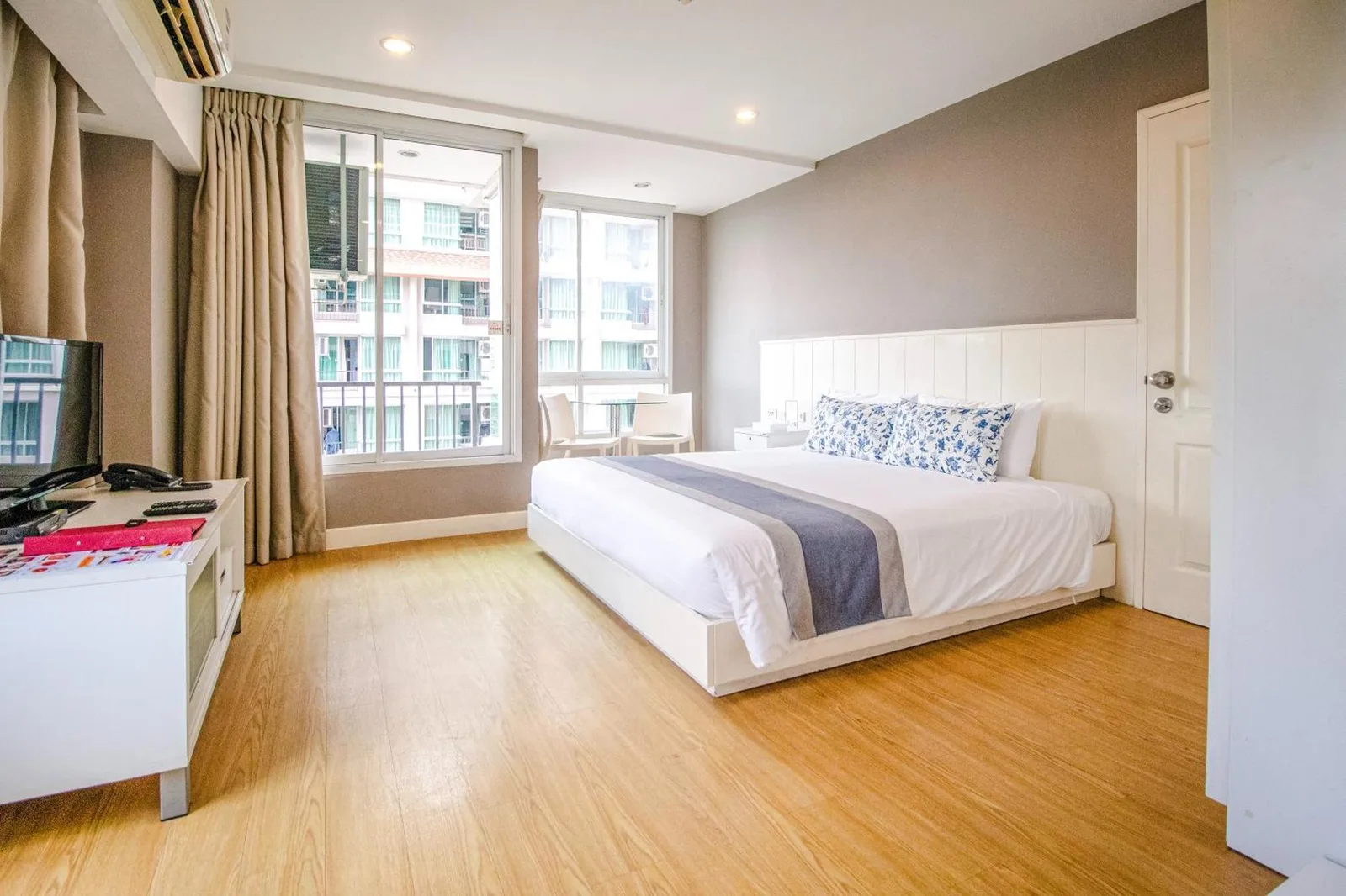 Chambre à Cinnamon Hotel Bangkok à Bangkok avec un lit king-size, de grandes fenêtres et un mobilier moderne et minimaliste