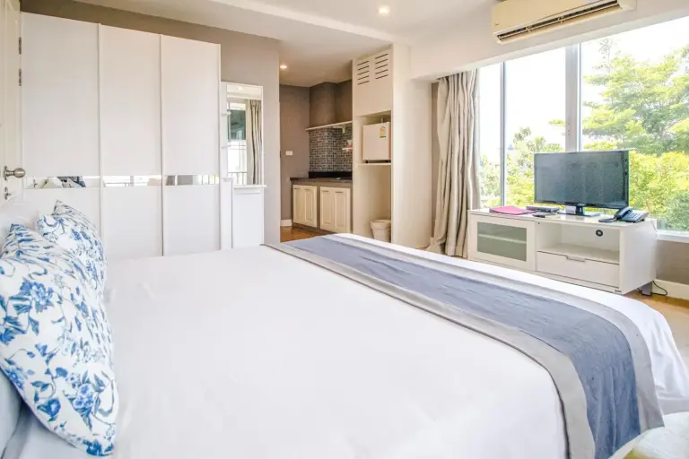 Vue de la chambre vers la kitchenette et la télévision à Cinnamon Hotel Bangkok à Bangkok