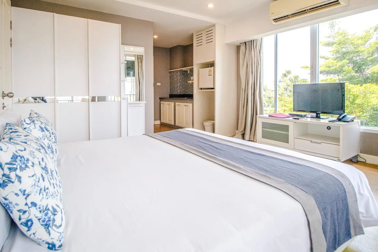 Vue de la chambre vers la kitchenette et la télévision à Cinnamon Hotel Bangkok à Bangkok