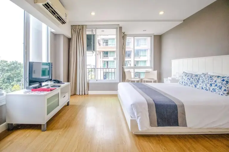 Chambre de style studio à Cinnamon Hotel Bangkok à Bangkok avec lit, TV, fenêtres et espace bureau