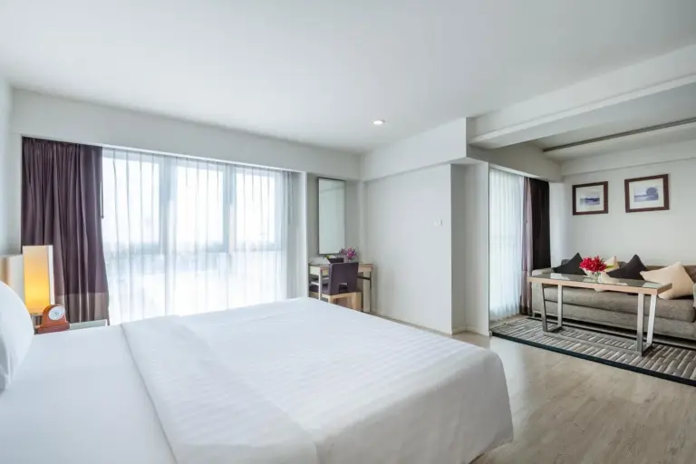 Large vue de la chambre au Classic Kameo Hotel & Serviced Apartments, Ayutthaya avec de grandes fenêtres et un coin salon.