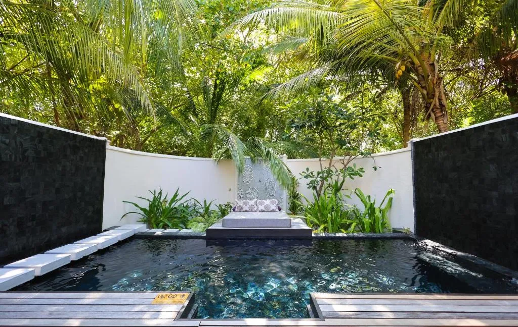 Tranquil private pool area surrounded by lush greenery at Coco Bodu Hithi.
