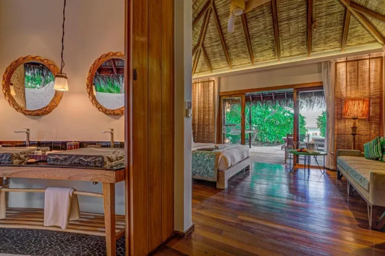 Badezimmer- und Schlafzimmerbereich in einer Villa im Constance Moofushi Maldives.