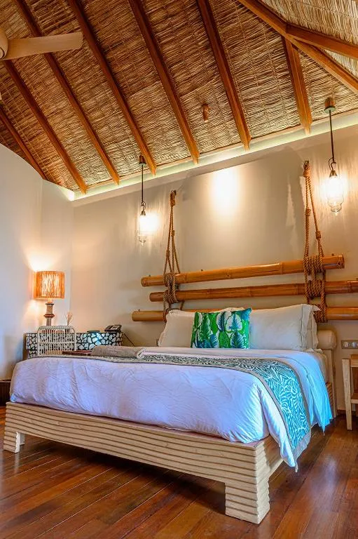 Gemütliches Schlafzimmer in einer Villa im Constance Moofushi Maldives mit Bambusdekoration.