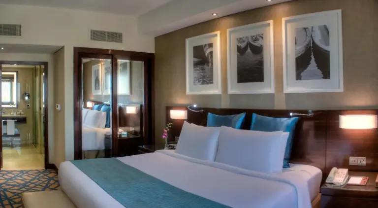 Chambre douillette au Crowne Plaza Dubai Deira à Dubai avec lit king-size et éclairage de chevet