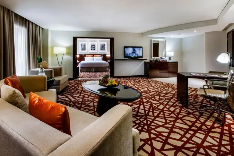 Vaste espace salon d'une suite exécutive au Crowne Plaza Dubai Deira à Dubai avec coin salon et accès à la chambre