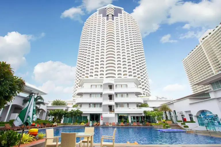 Exterior view of D Varee Jomtien Beach, Pattaya with the high-rise tower and swimming pool in the foreground.